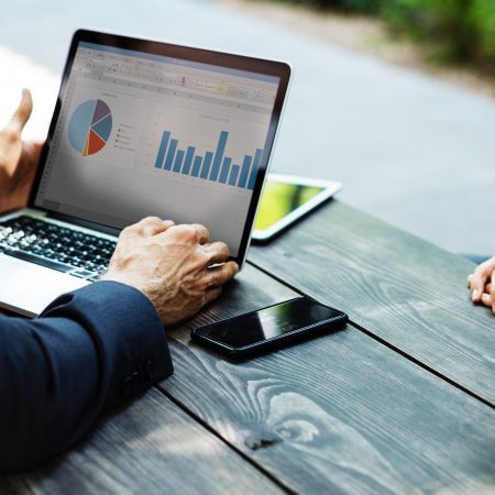 Photo of person's hands while viewing accounting charts on laptop