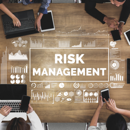 Risk Management written on table with laptops