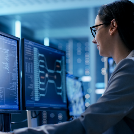 Photo showing woman coding on computers in dark room