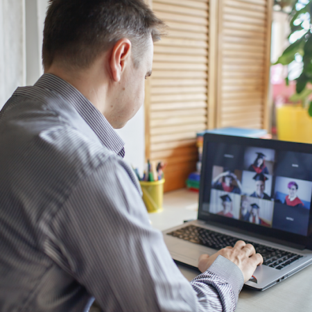 Photo of a man on a Zoom call with graduates